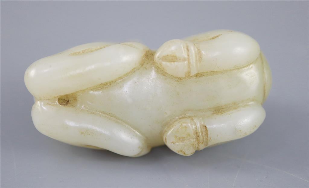 A Chinese pale celadon jade figure of a recumbent qilin, 5.4cm